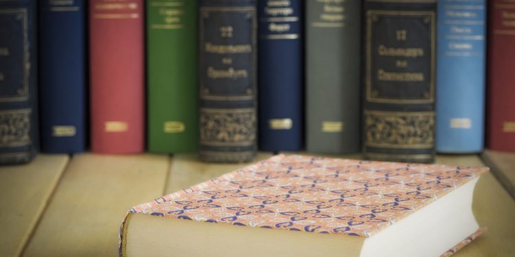 Closed book in front of several books on the table